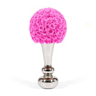 Decorative object with pink rose ball on a silver base against a white background