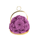 Purple roses in a gold container on a white background